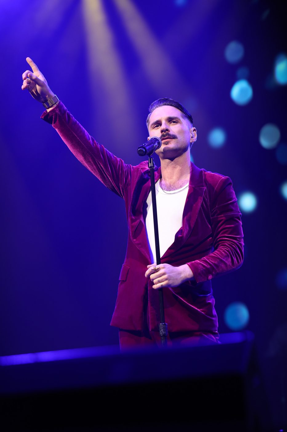 Joshua Sade James performing live in a crimson velvet suit — concert photography by Violet Crowned Media, featured by Zoë Tyler International